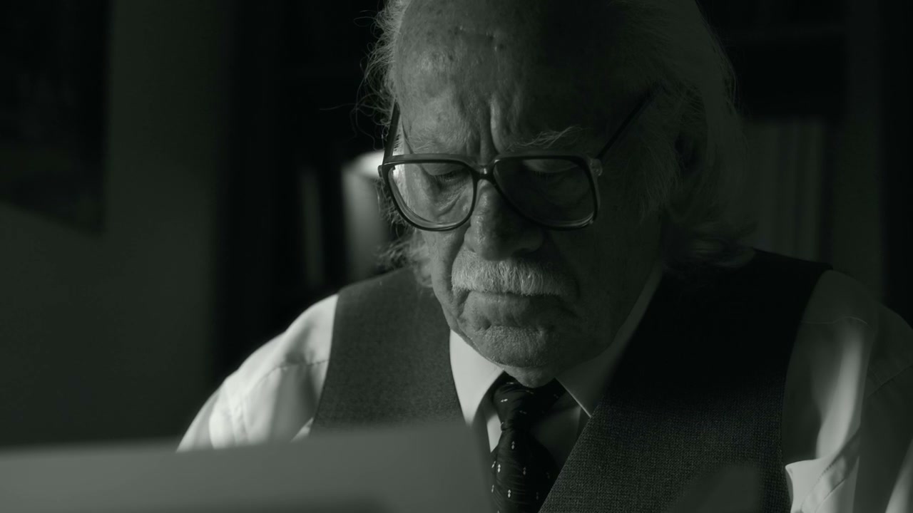 Senior Man Pondering Document in Black and White