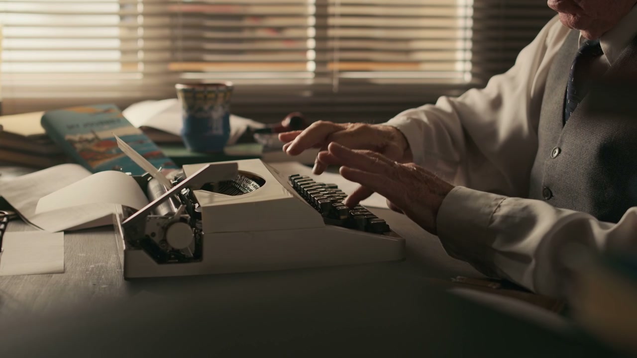 Elderly Author Typing on a Vintage Typewriter