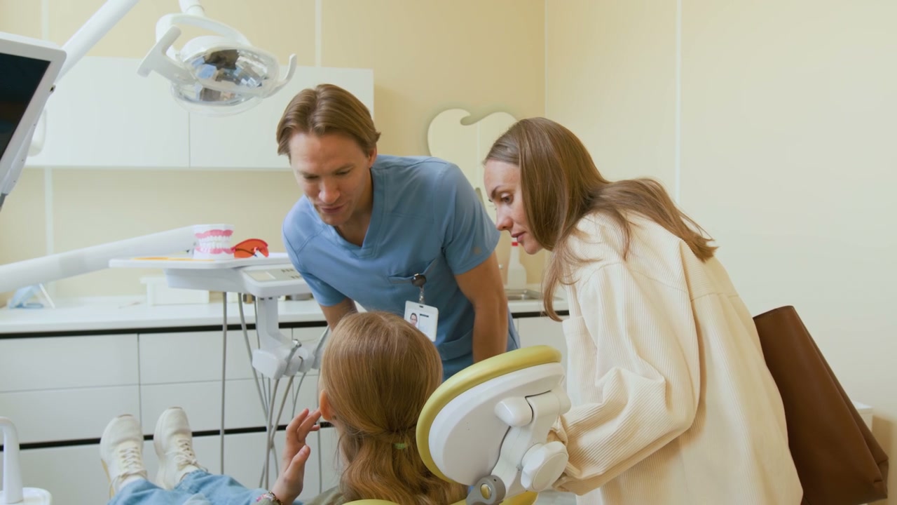 Dentist Talking to Mother and Child in Clinic