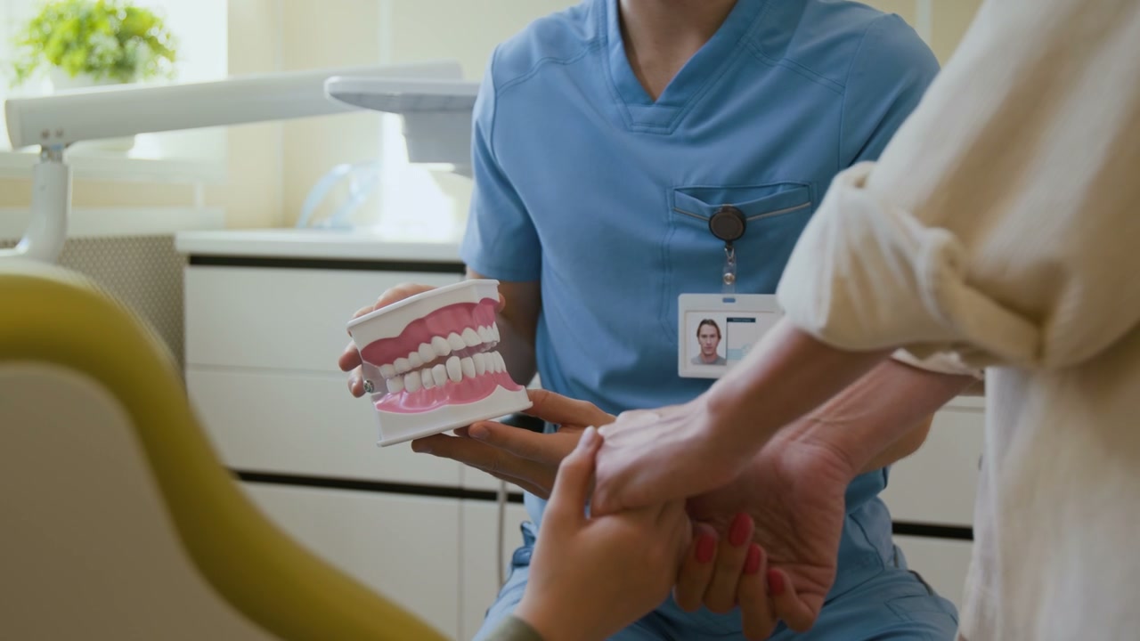Dentist Explaining Teeth Model to Child and Parent