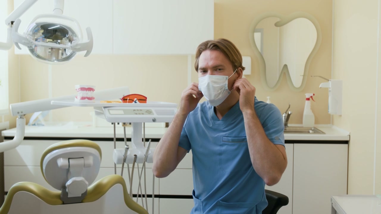 Male Dentist Removes Mask and Smiles