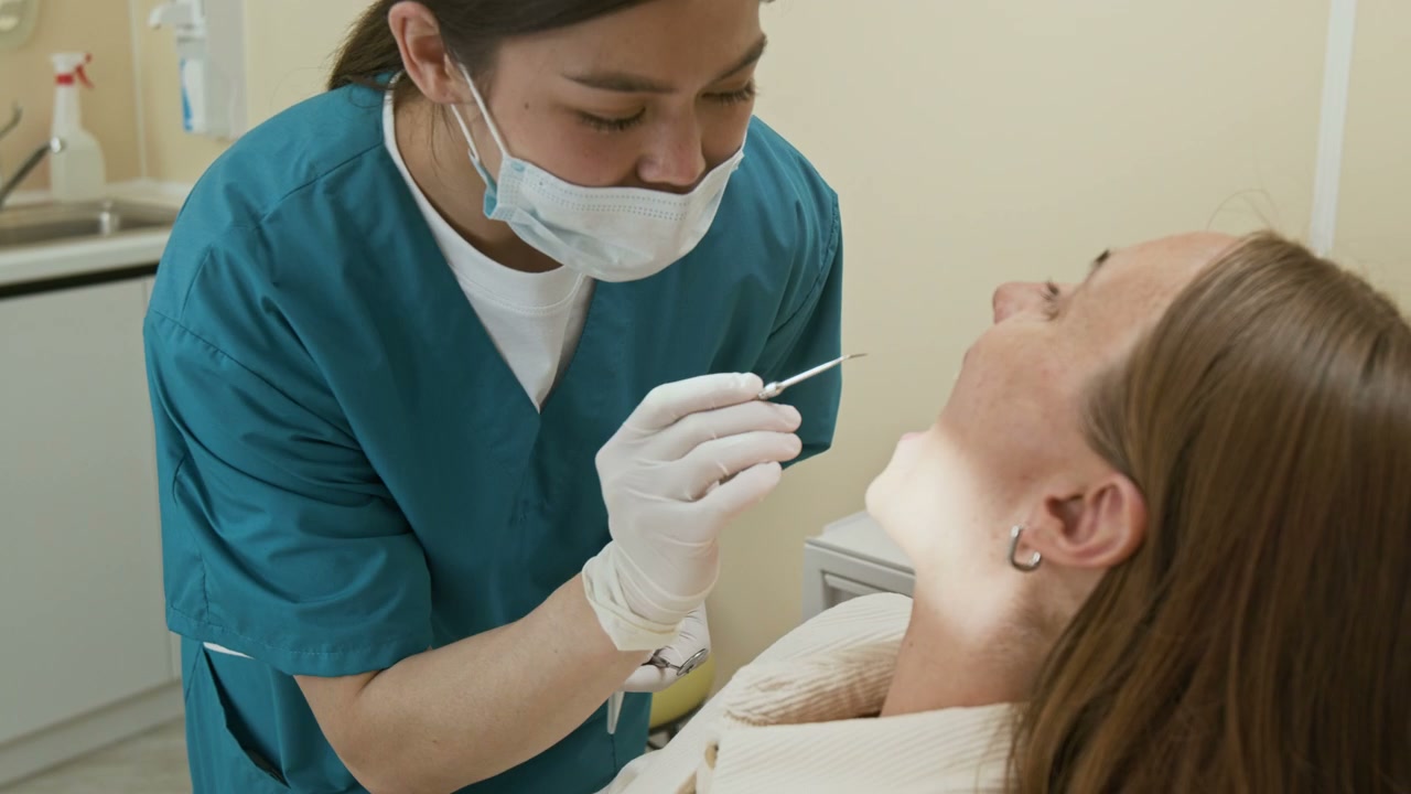 Female Dentist Examining Patient's Teeth