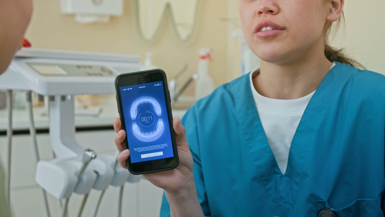 Dentist Explaining Dental App to Patient