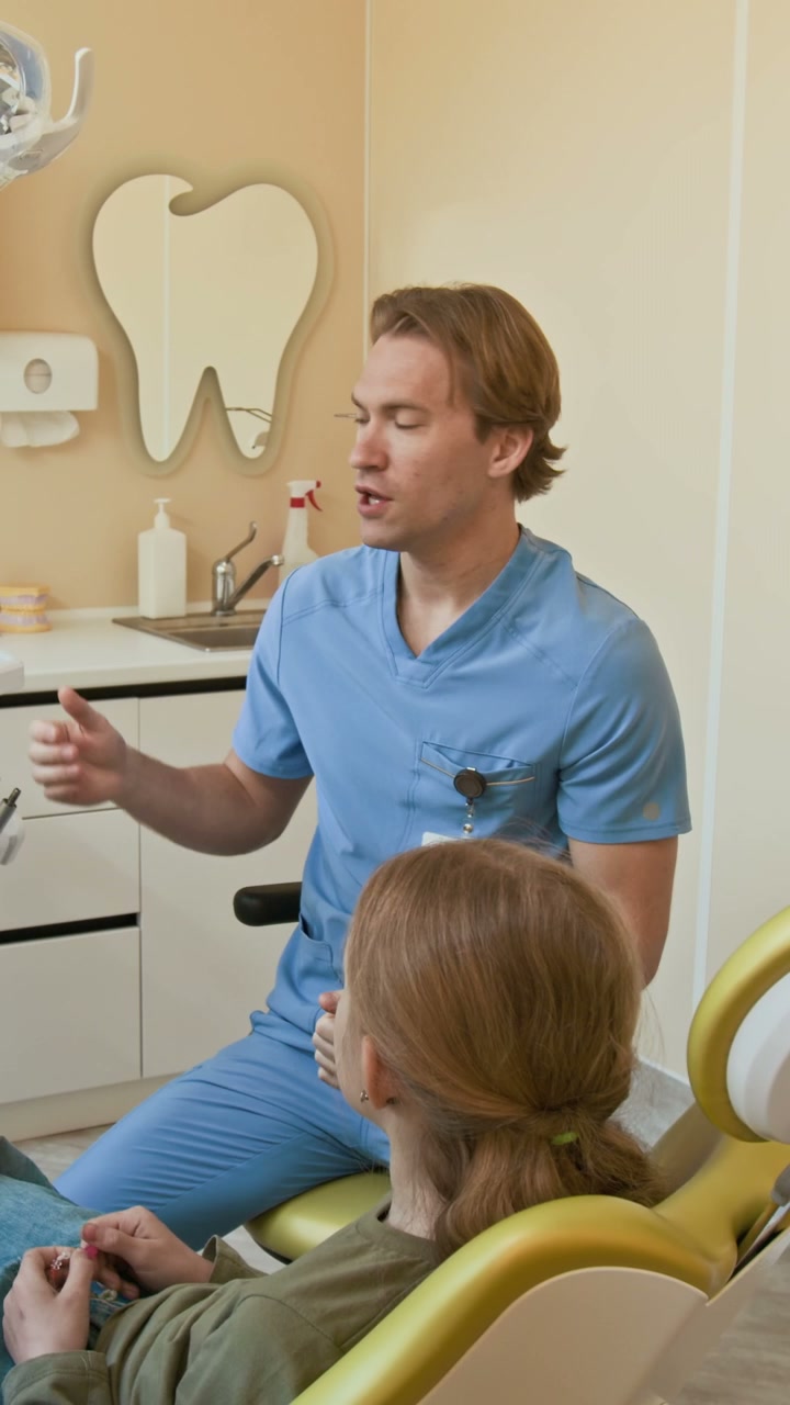 Dentist Explaining Dental Model to Child Patient