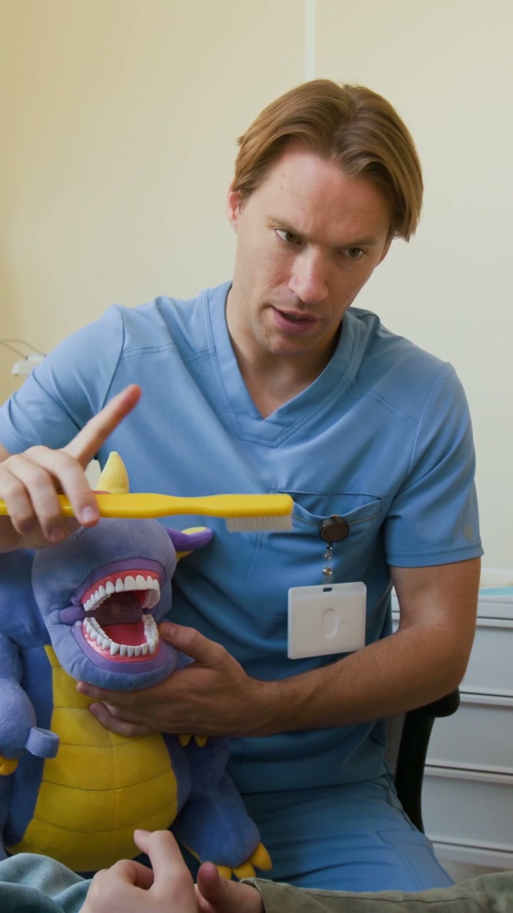 Dentist Demonstrates Brushing to Child