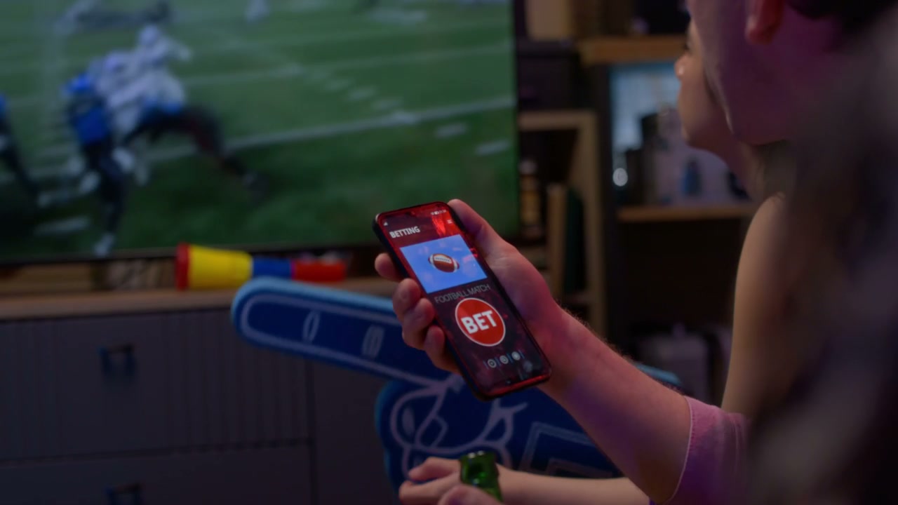 Person Betting on Football Match on Smartphone