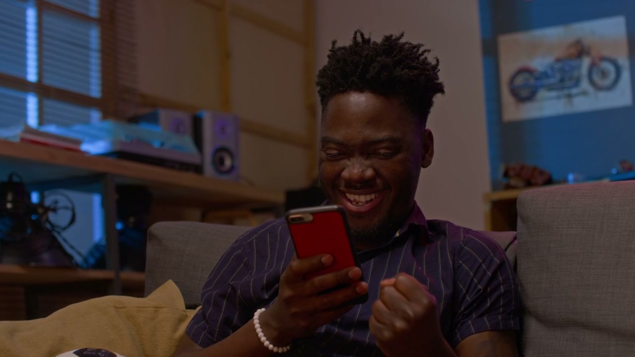 Excited Man Celebrating Win on Smartphone