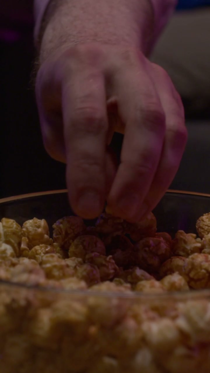 Hand Taking Popcorn During Night Entertainment