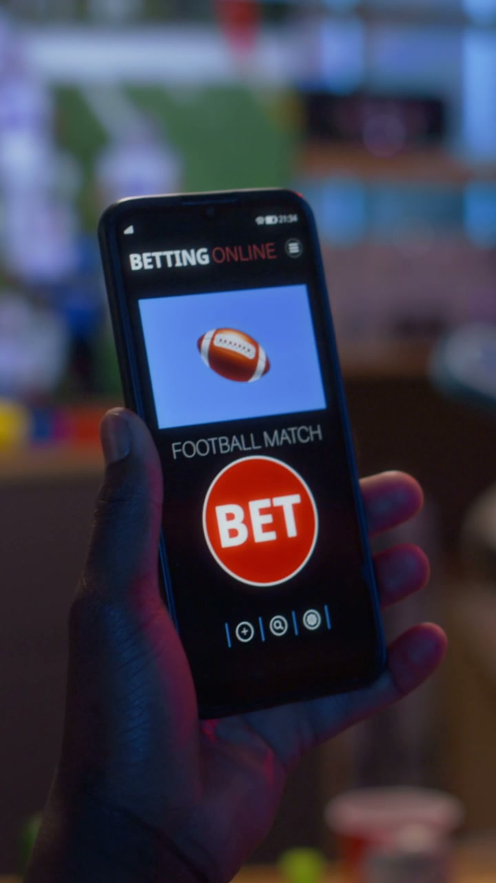 Hand Holding Phone With Online Football Betting App