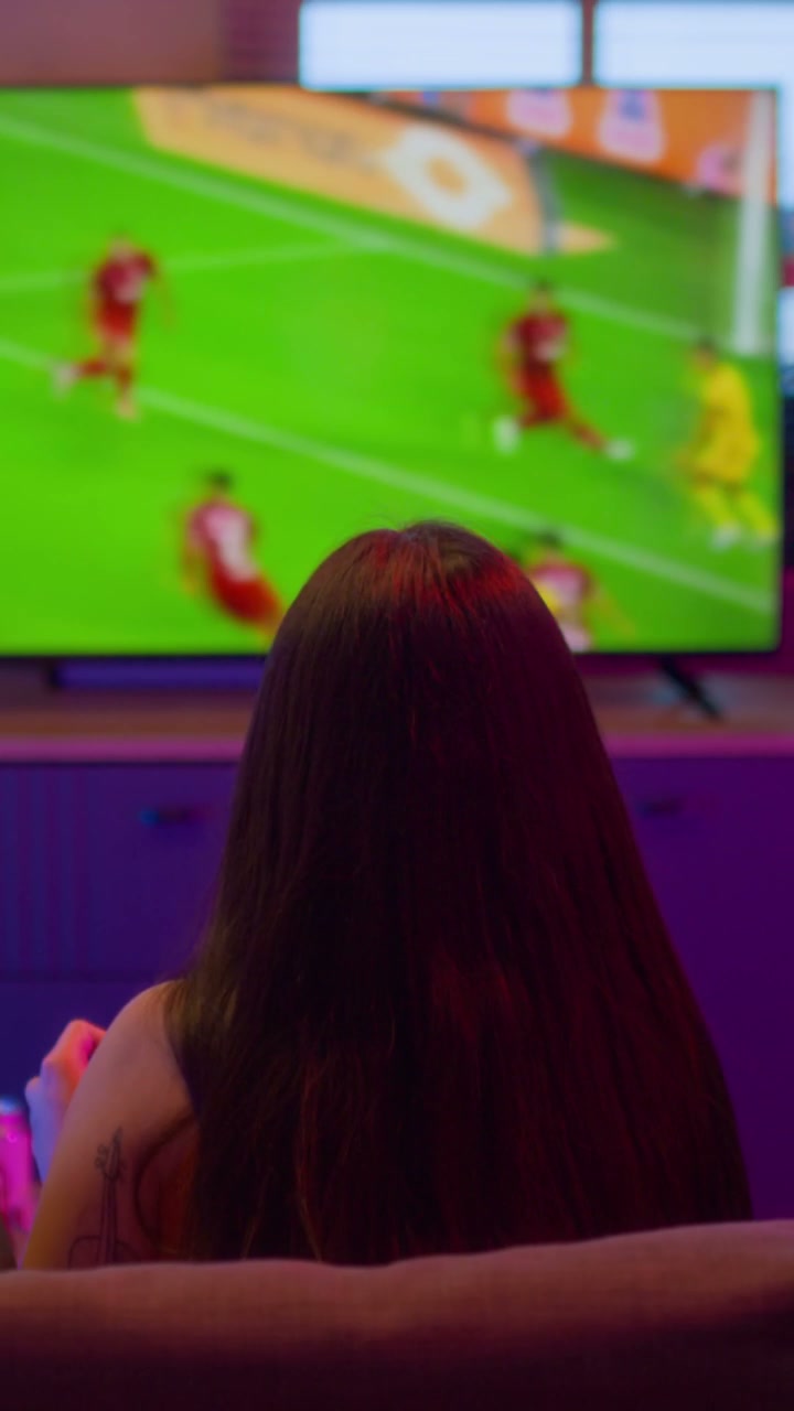 Person Watching Football and Using Betting App