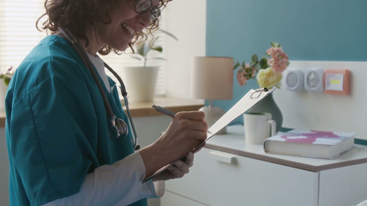 Healthcare Worker Writing on Clipboard and Smiling