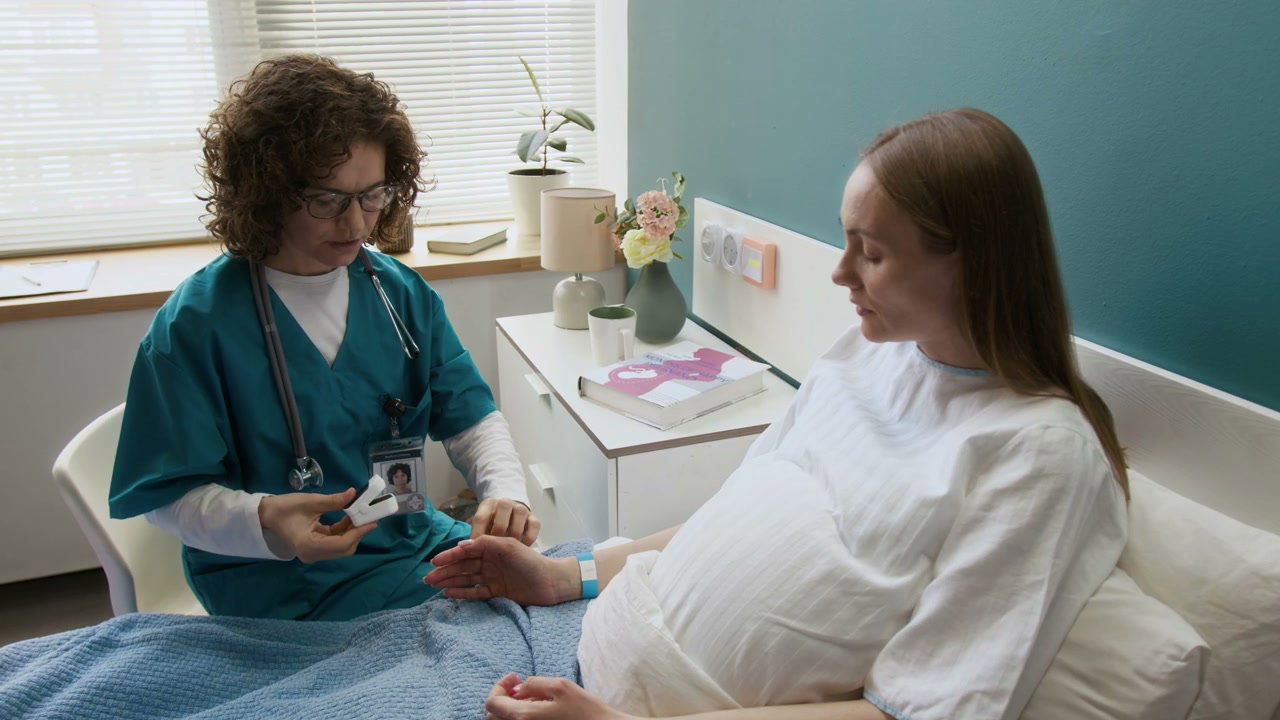 Nurse Checks Pulse Oximeter on Pregnant Woman