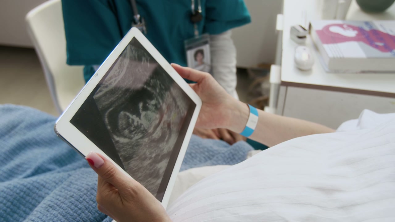 Doctor Shows Ultrasound Scan to Pregnant Patient