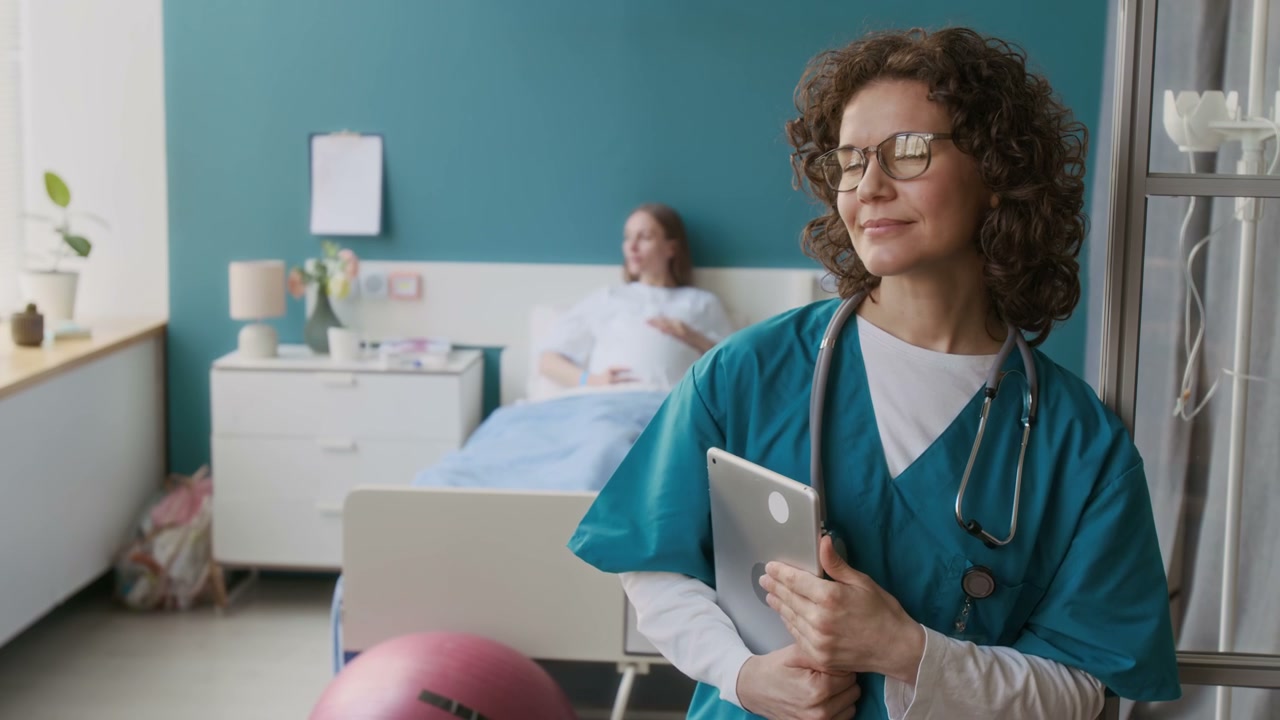 Doctor Smiles in Maternity Ward with Patient