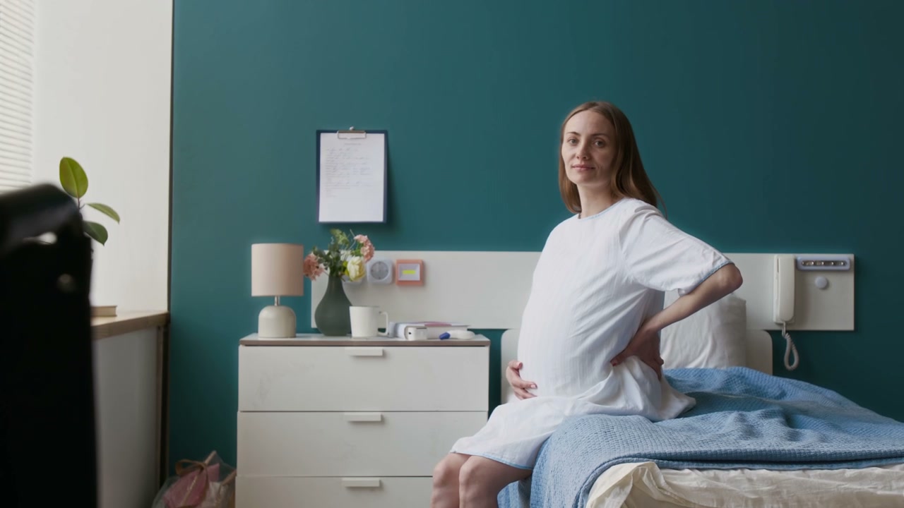 Pregnant Woman Smiling in Hospital Room