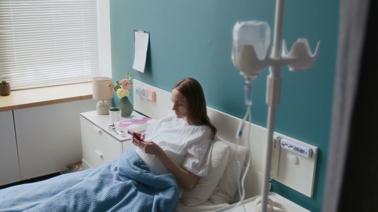 Pregnant Woman in Hospital Bed Using Phone