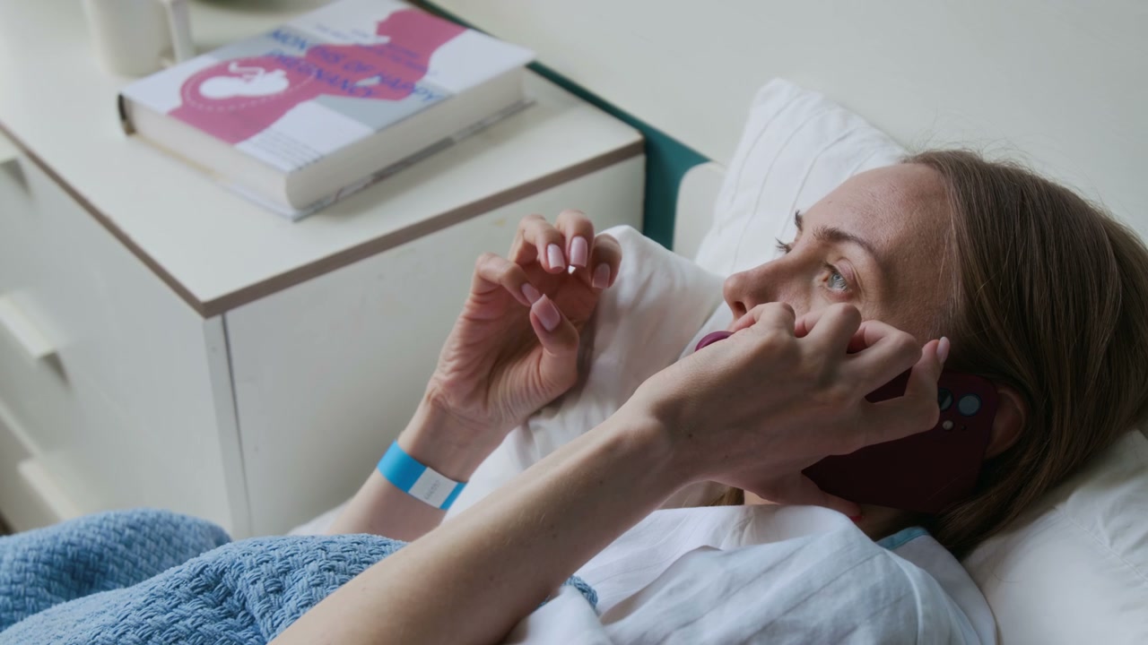 Pregnant Woman on Phone in Hospital Bed