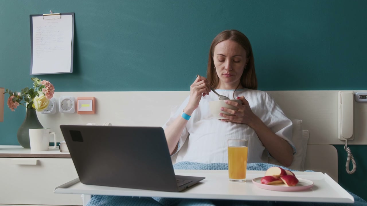 Pregnant Woman Eating Breakfast in Hospital Bed