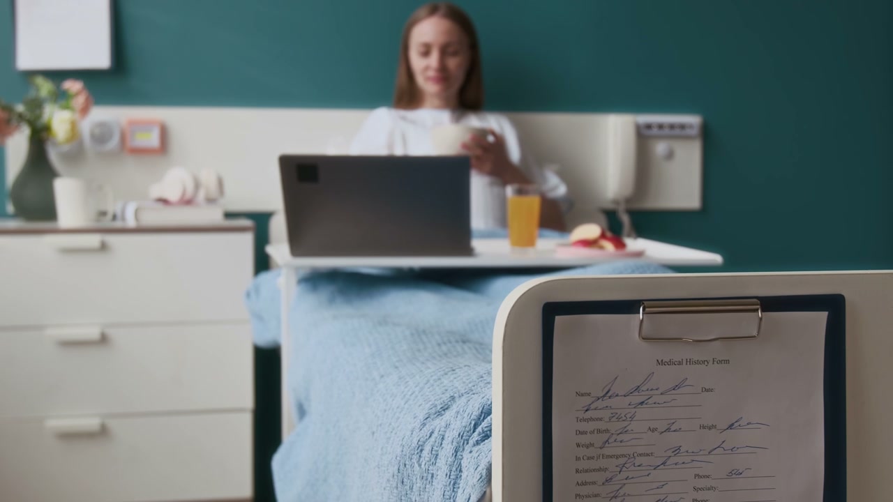 Woman Having Breakfast with Laptop in Hospital Bed