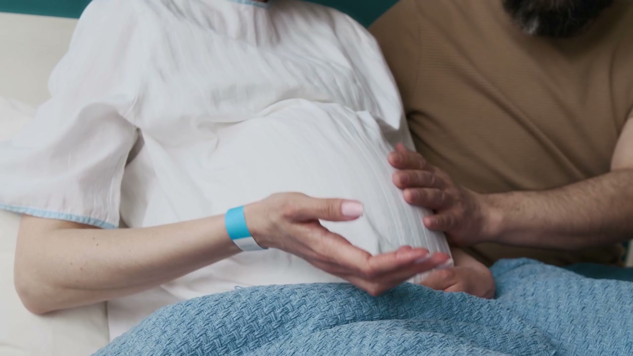 Pregnant Person and Partner Stroking Belly