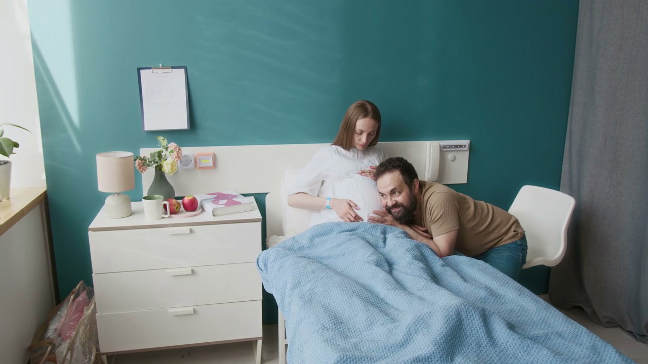Expectant Father Listens to Pregnant Belly