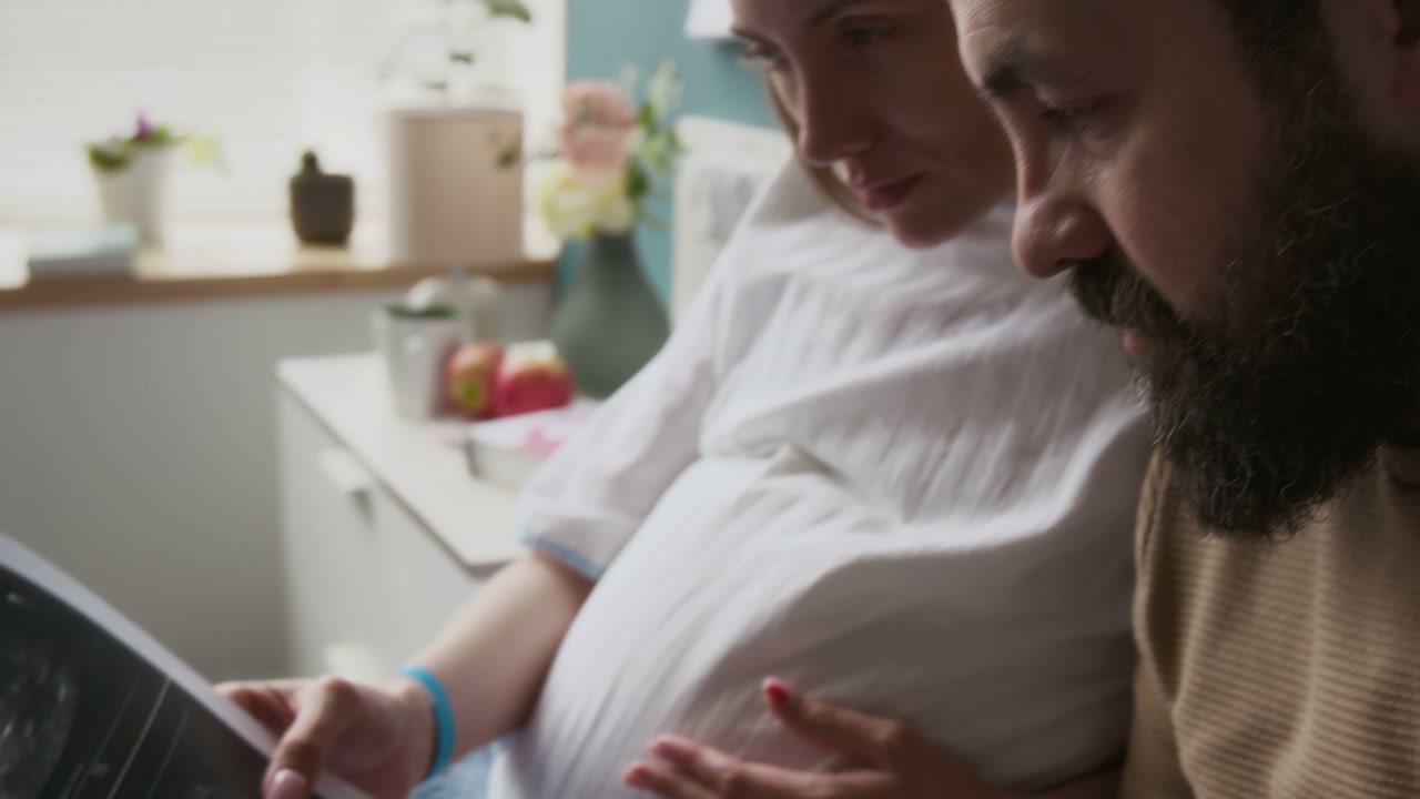 Pregnant Couple Examining Ultrasound Scan