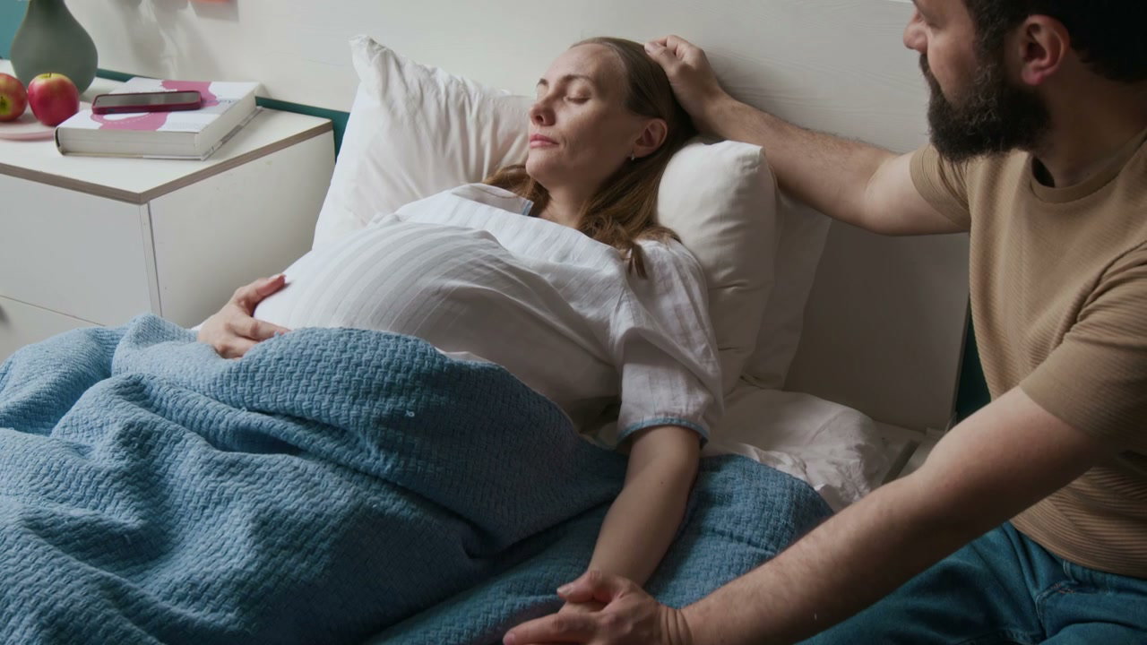 Man Comforting Pregnant Woman in Hospital