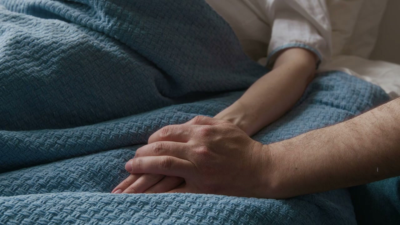 Man Supports Pregnant Woman in Hospital Bed