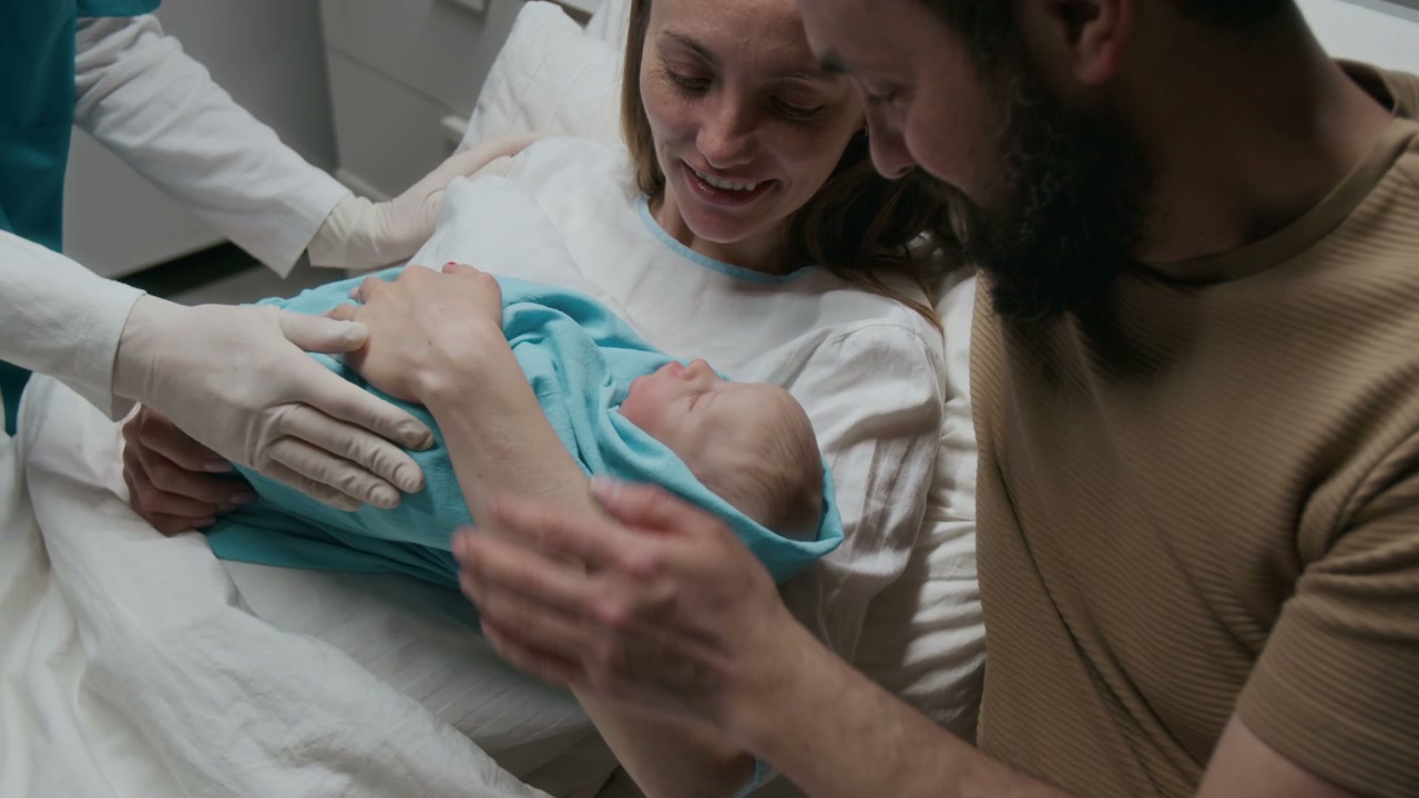 New Parents Cradling Newborn Baby in Hospital