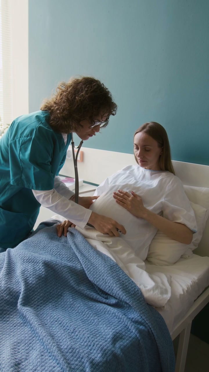 Doctor Examining Pregnant Woman's Belly with Stethoscope