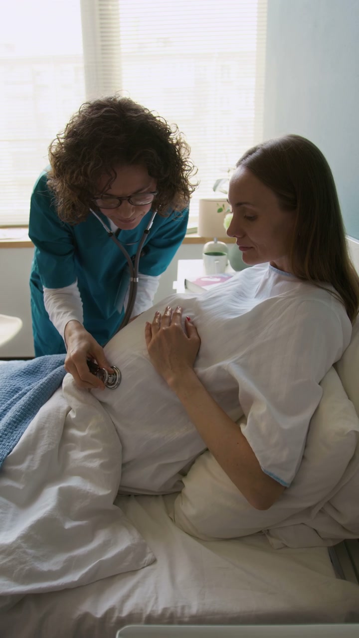 Doctor Examines Pregnant Woman with Stethoscope