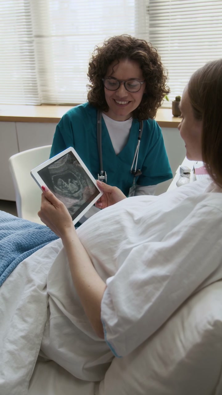 Doctor Explaining Ultrasound to Pregnant Woman
