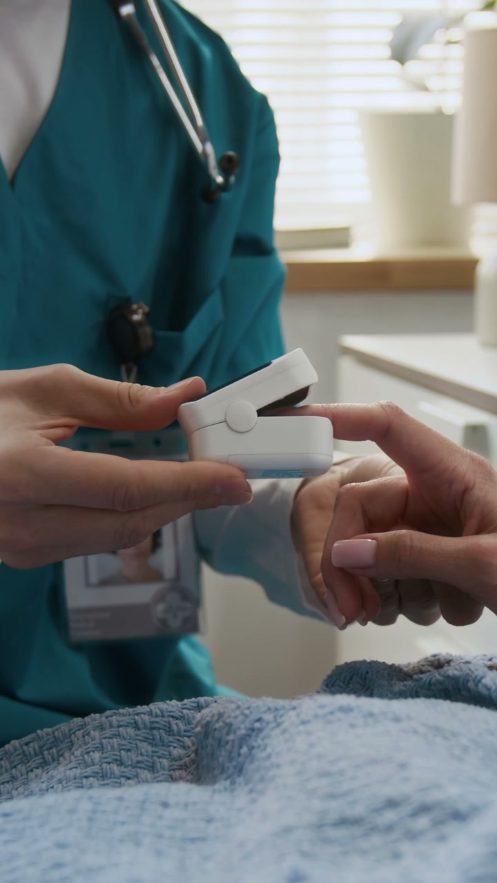 Nurse Attaching Pulse Oximeter to Patient
