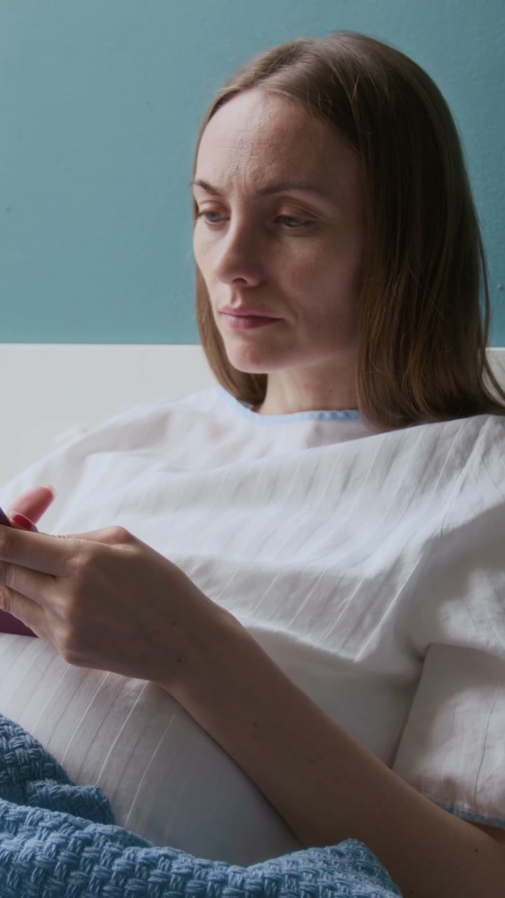 Pregnant Woman Using Smartphone in Hospital Bed