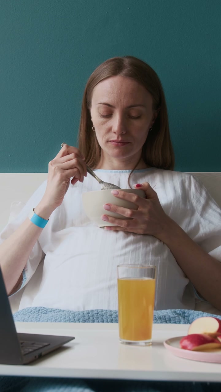 Pregnant Woman Eating Breakfast in Bed