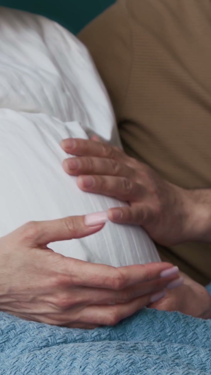 Expectant Couple's Hands on Pregnant Belly