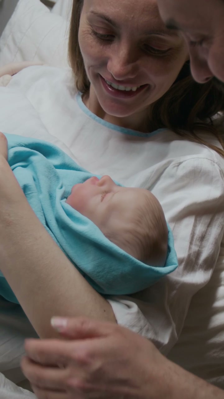 Happy Parents Admire Newborn Baby in Hospital