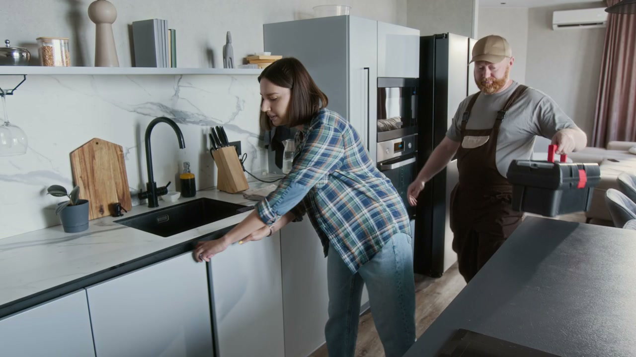 Plumber Inspects Kitchen Sink Leak