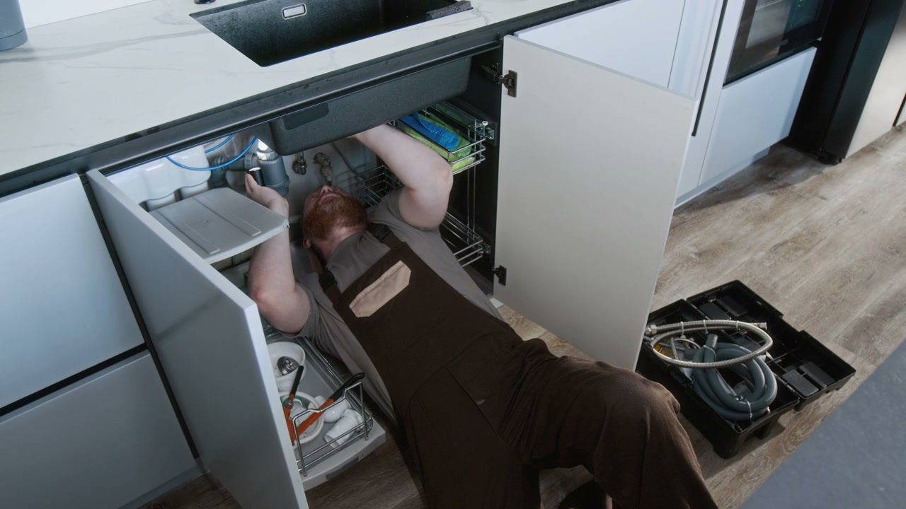 Repair Worker Under Kitchen Sink