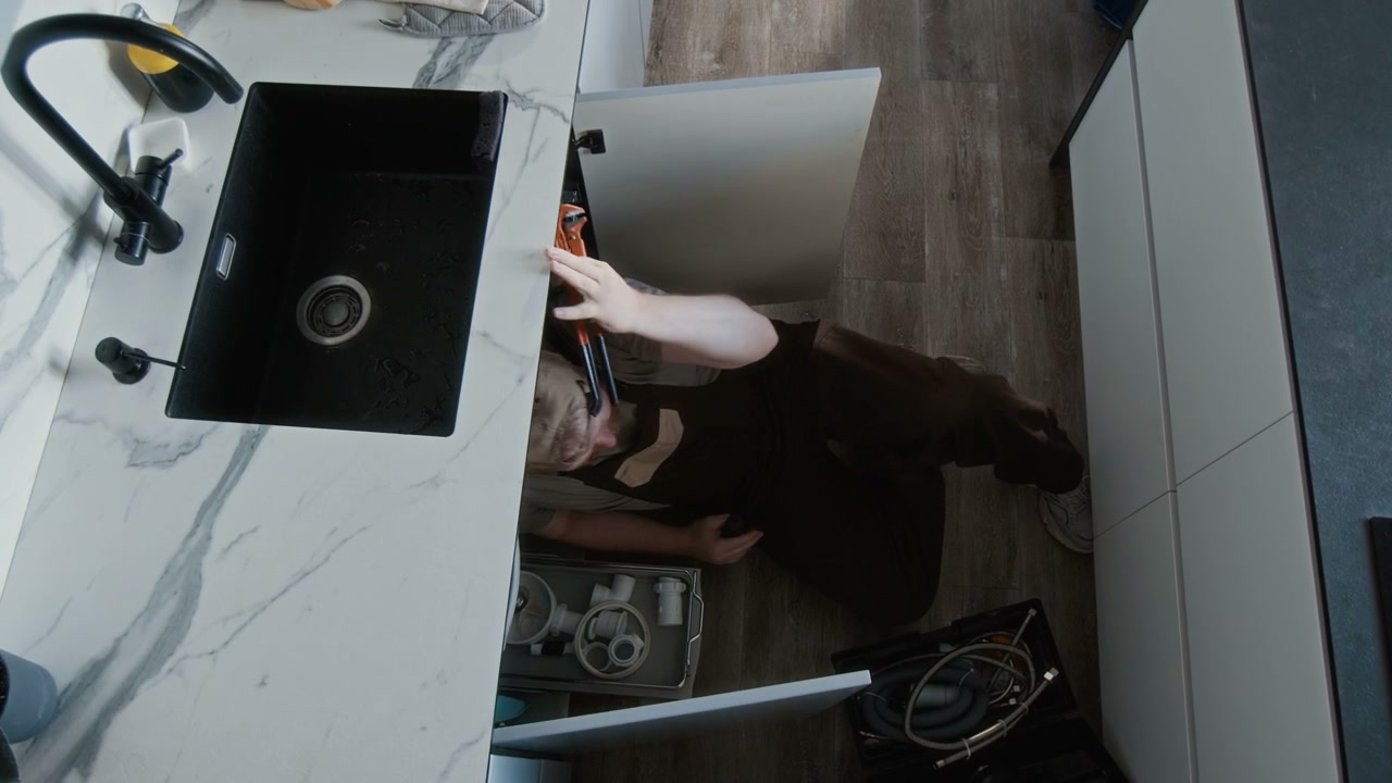 Plumber Repairing Kitchen Sink