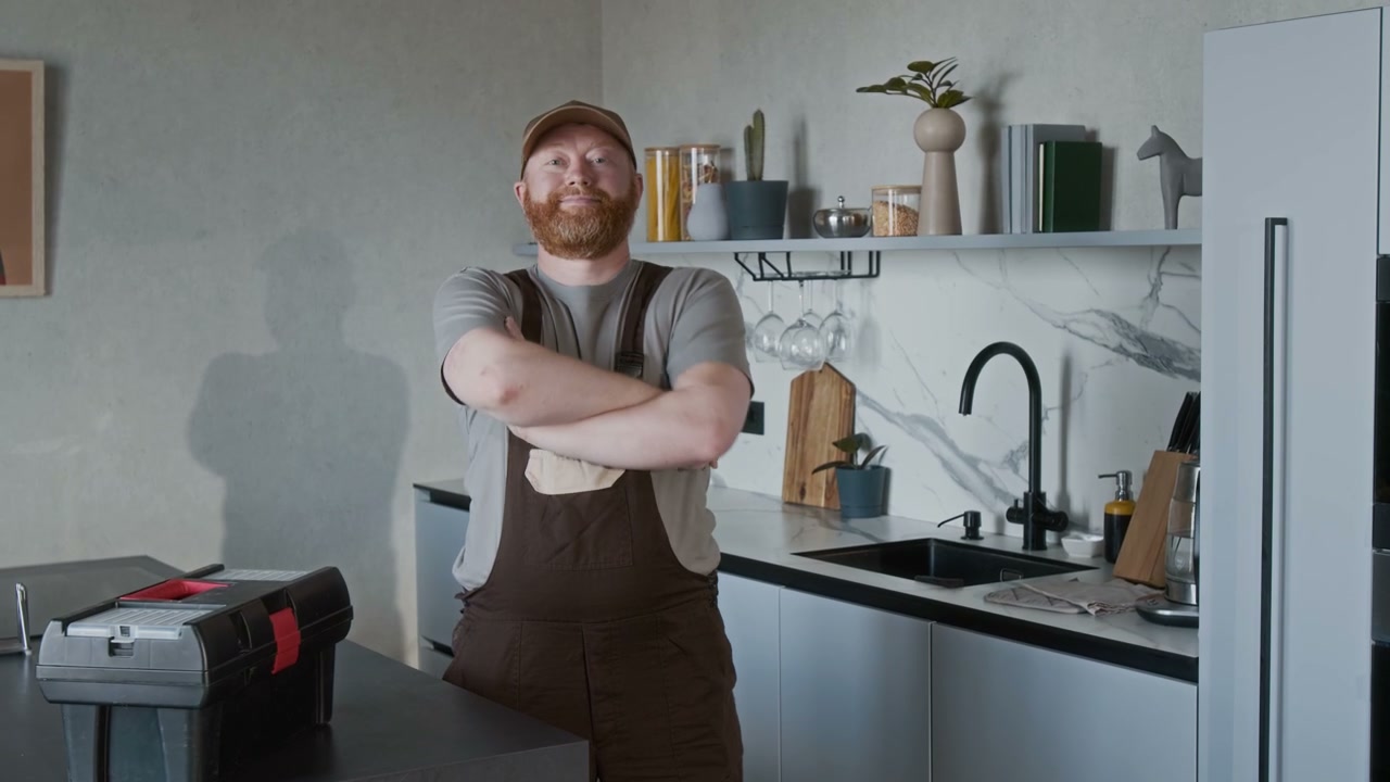 Confident Plumber Posing in Modern Kitchen
