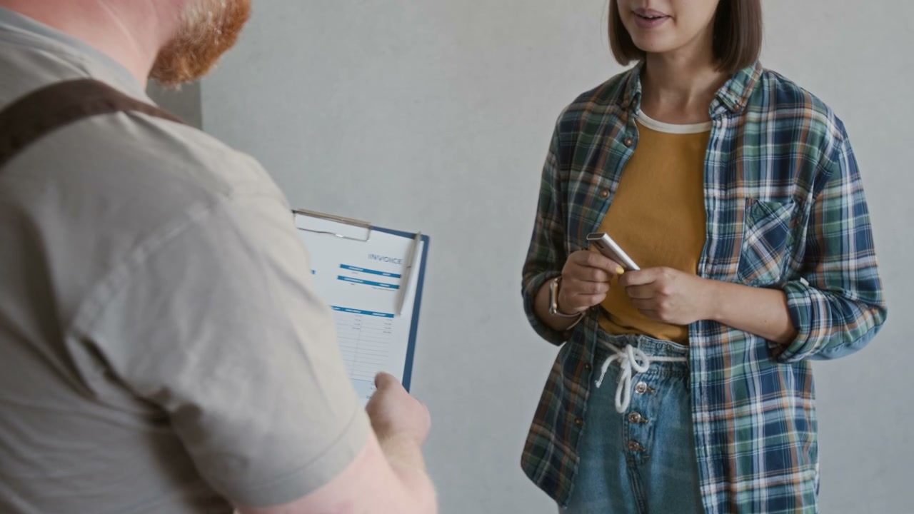 Repairman and Client Handshake with Invoice