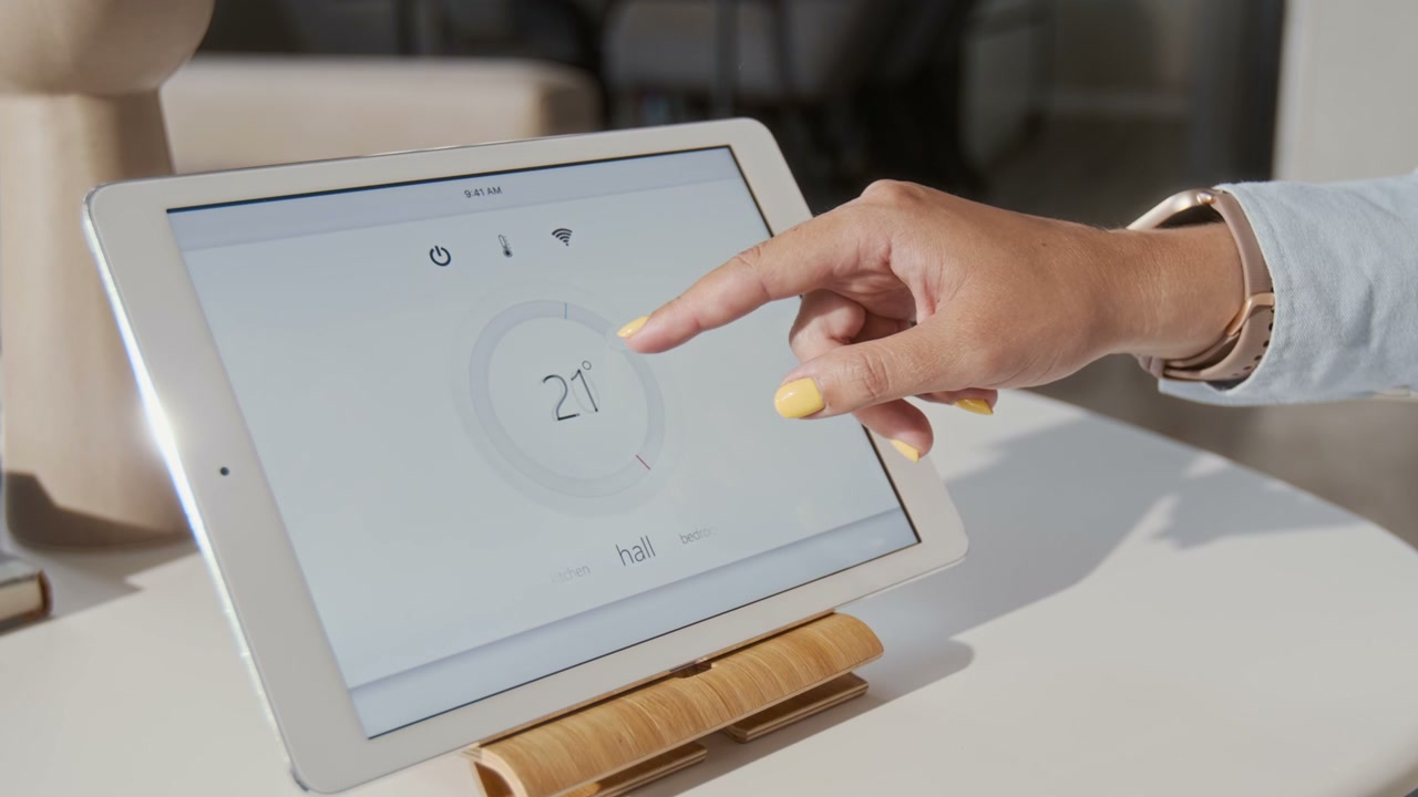 Hand Adjusting Smart Home Temperature on Tablet