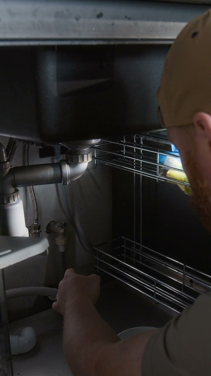 Plumber Repairing Kitchen Sink Pipe