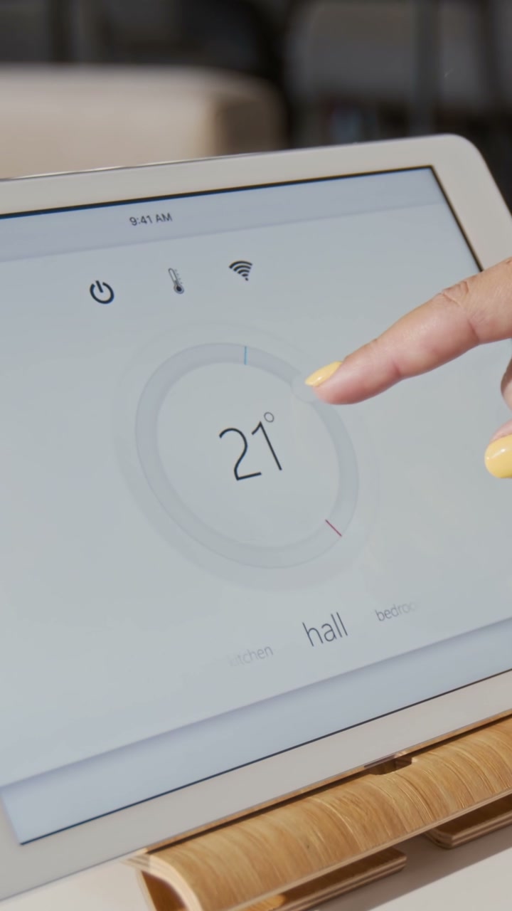 Person Adjusting Smart Home Temperature on Tablet