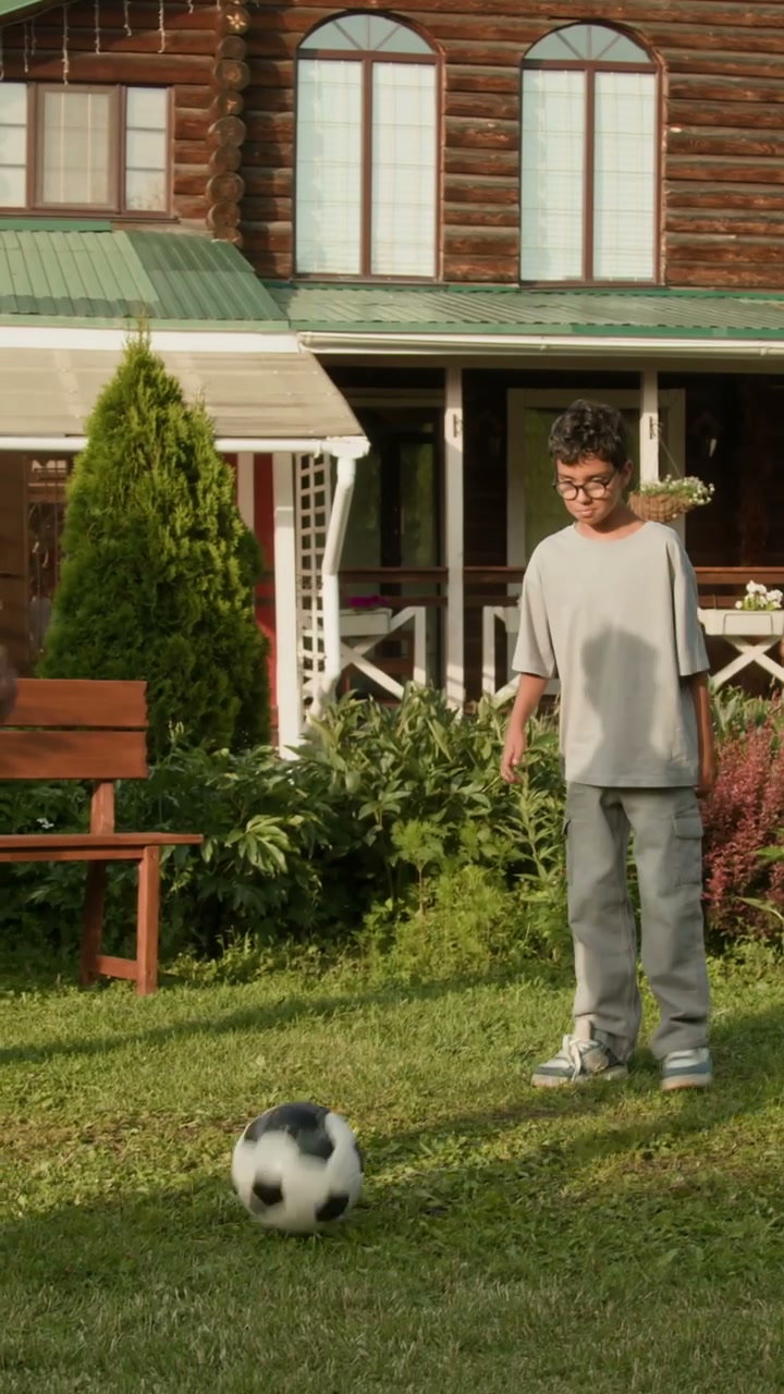 Boy and Man Playing Football in Garden