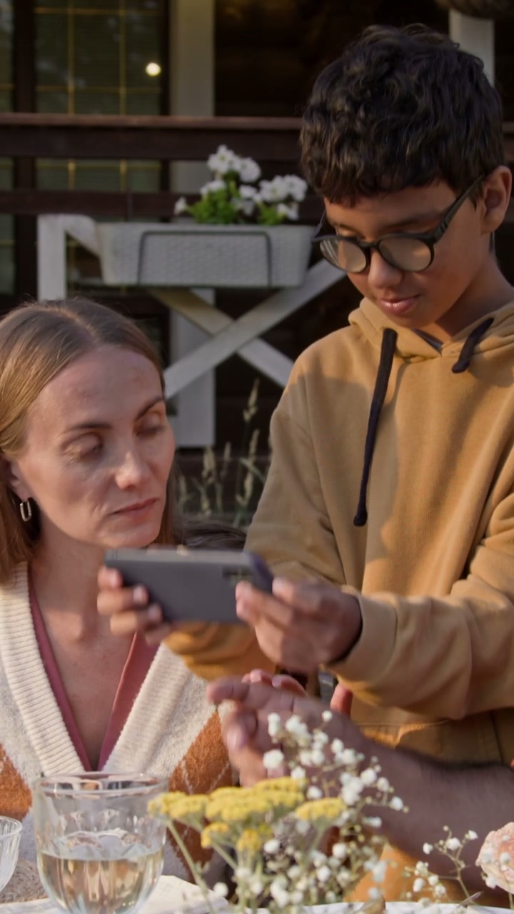 Mother and Son Looking at Smartphone Outdoors
