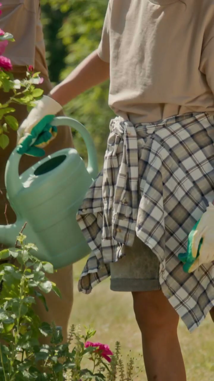 Two Gardeners Watering Roses
