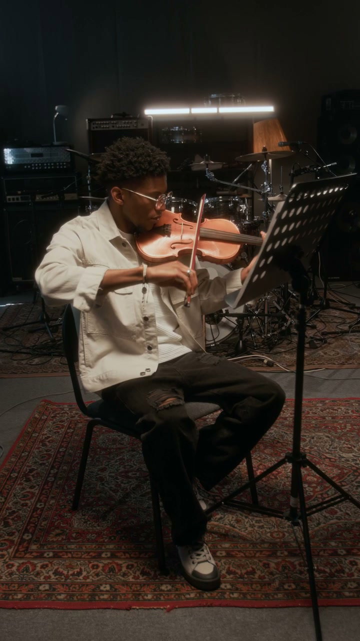 Young Man Playing Violin in Music Studio