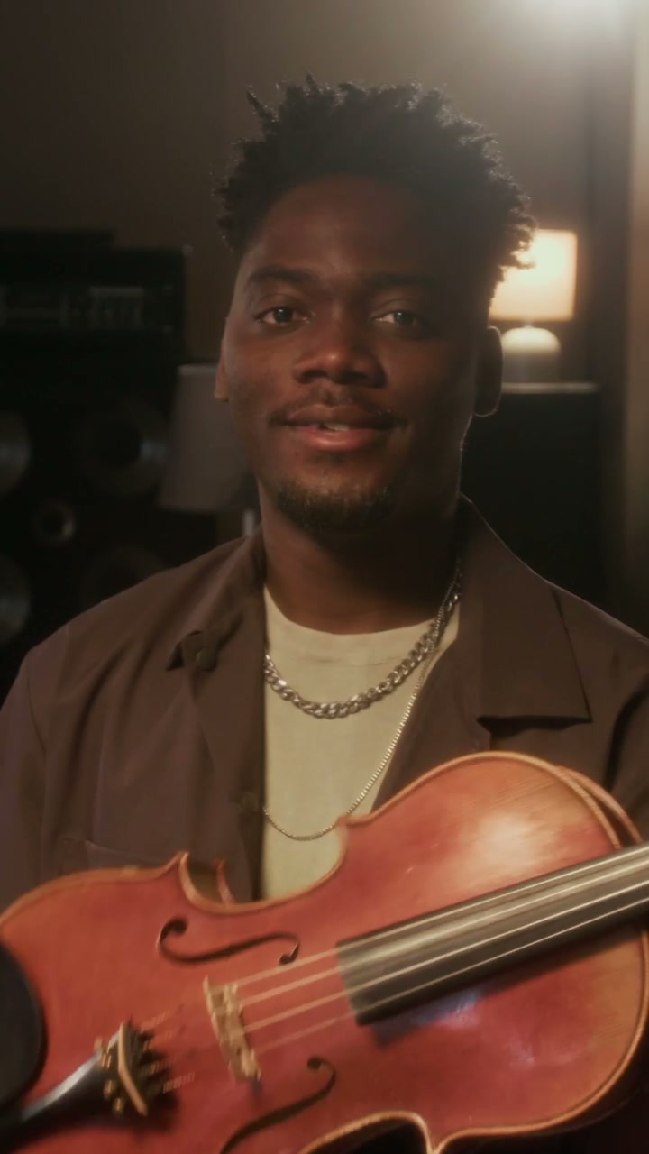 Smiling Violinist Holding Instrument in Studio